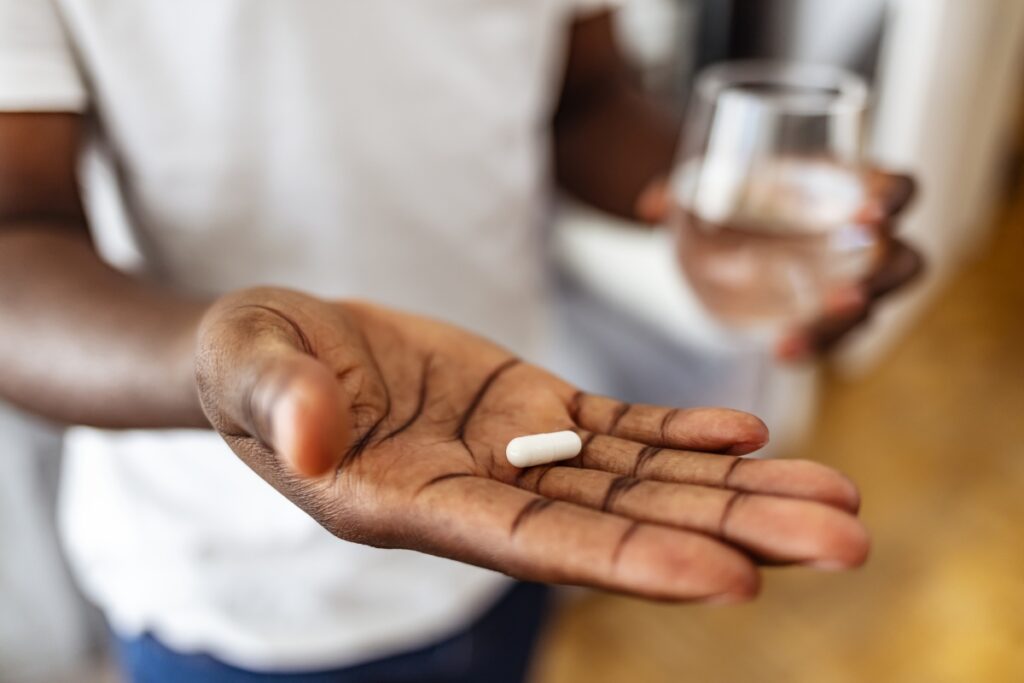 man showing a magnesium pill