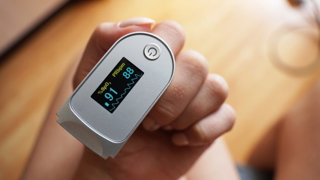 hand with a fingertip pulse oximeter 