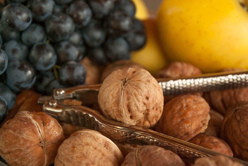 A handful of nuts with a nutcraker and berries