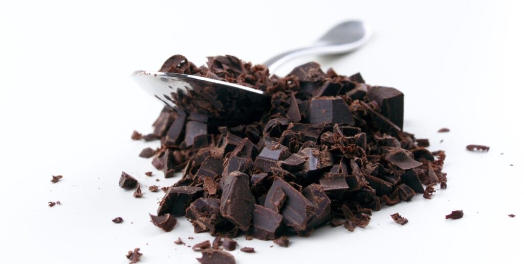 Chopped dark chocolate in a spoon 