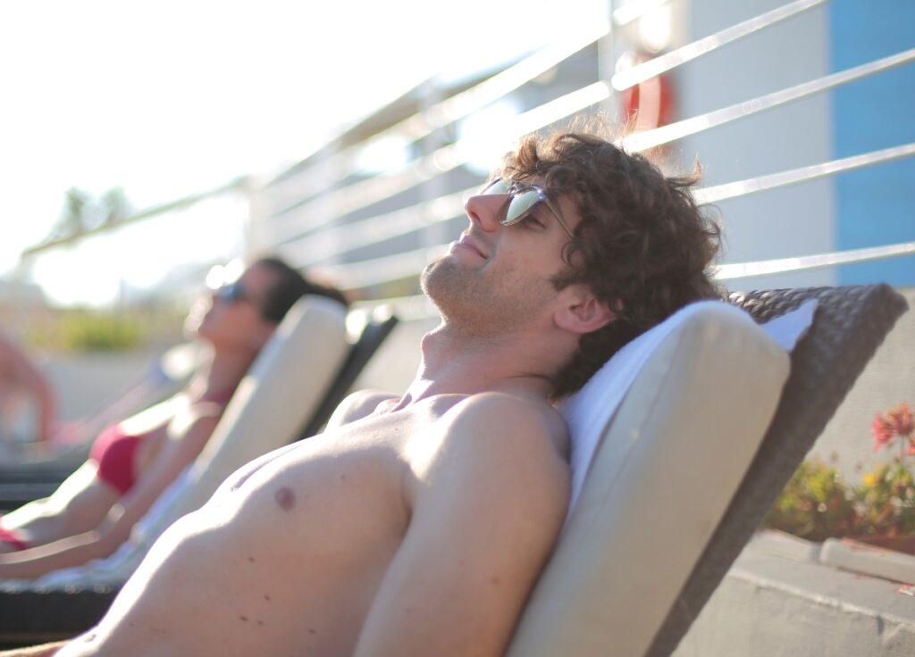 A couple realing and taking the sunlight a the pool