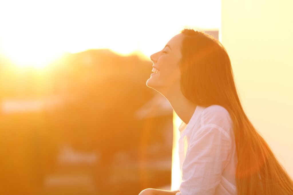 A profile of a woman smiling into the sunset