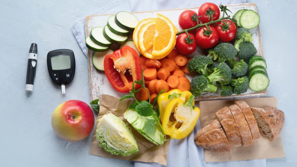 A table with a glucometer and fresh fruits and vegetables