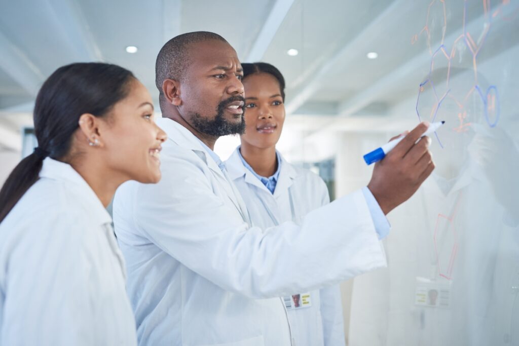 A group of scientist drawing a molecule in a board