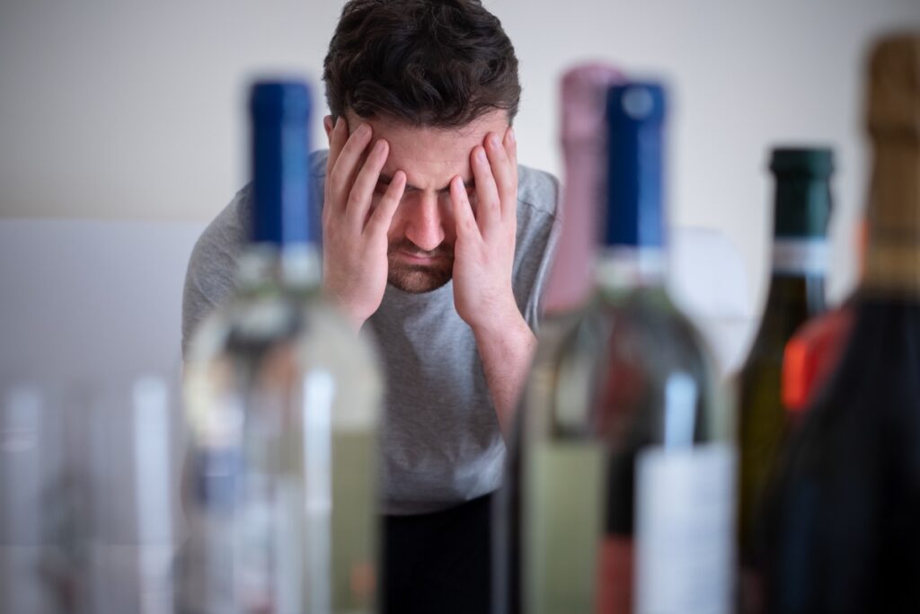 person hangover with his hands over his head