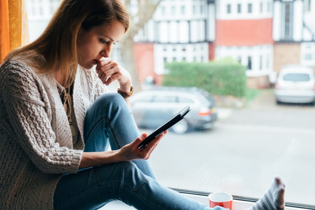 person anxious using a tablet to read the news