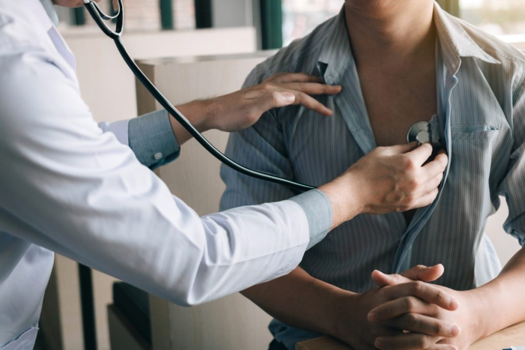 doctor is using a stethoscope listen to the heartbeat of an elderly patient.