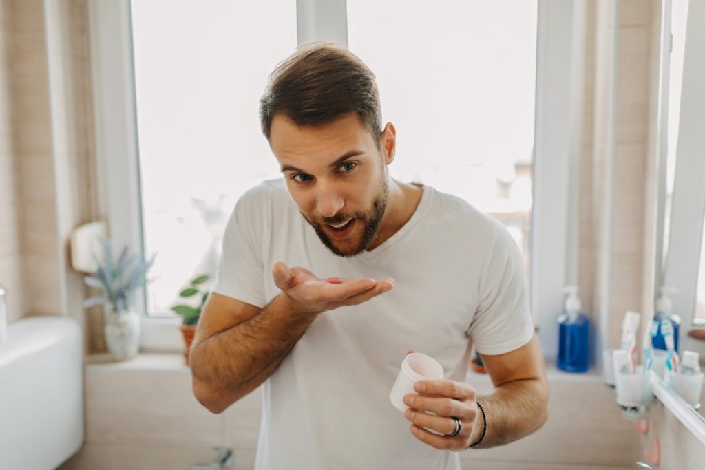 young man getting ready in the morning taking vitamins