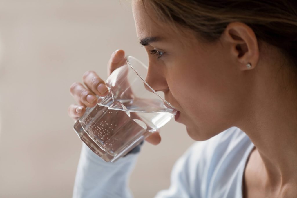 woman drinking pure water from glass
