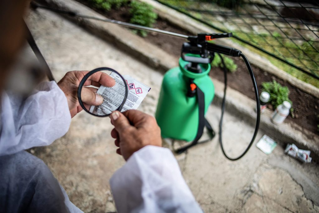 The farmer reads the instructions for spraying fruit against parasites, working on a farm in the village