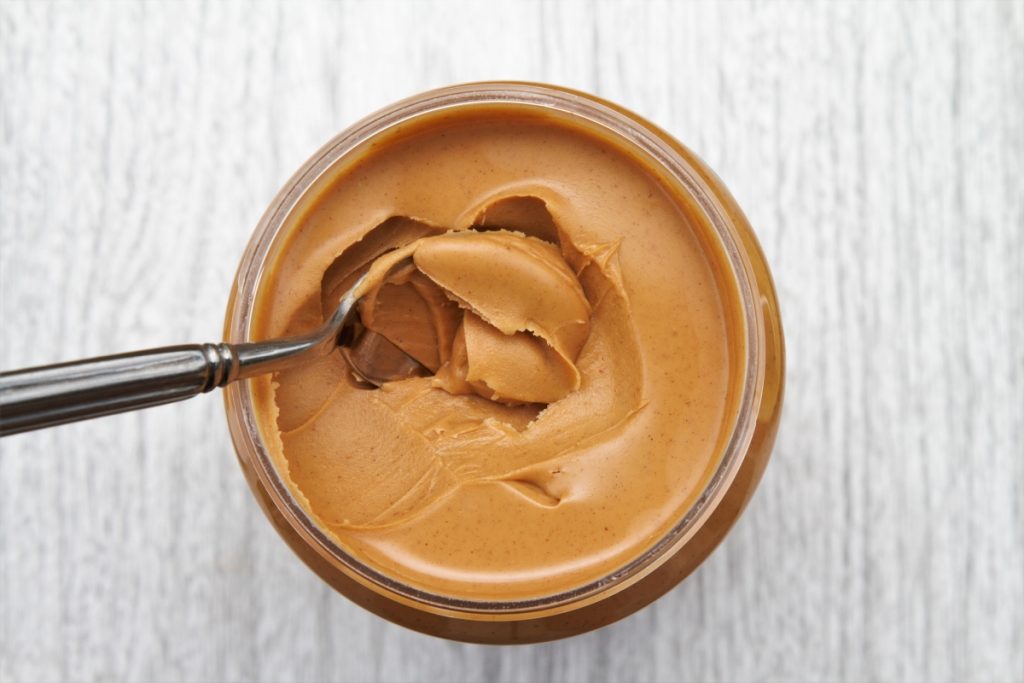 Spoon in a jar of peanut butter.