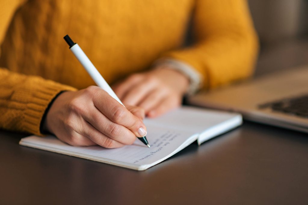 A shot of a person journaling and tracking their habits