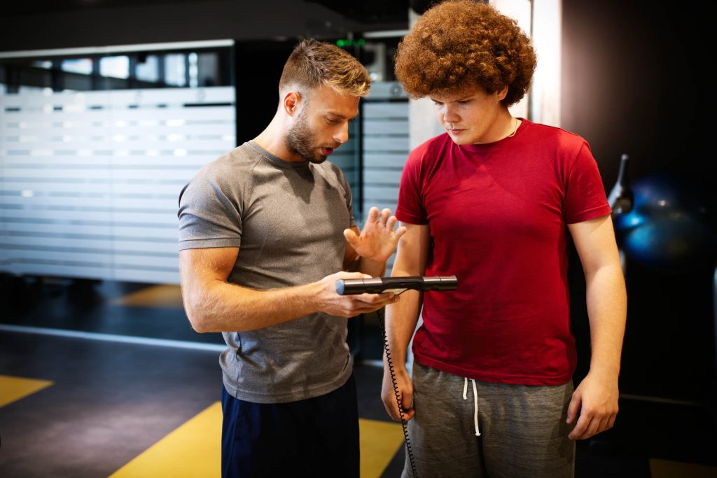 A nutritional and fitness coach helping a young adult 