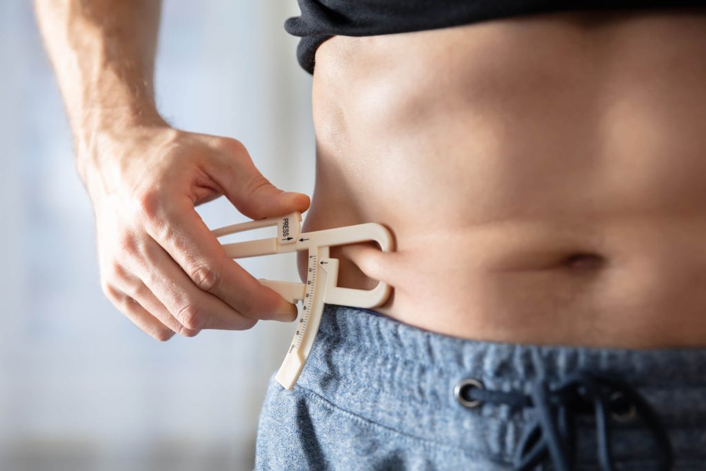 Measuring His Body Fat With Caliper In The Gym