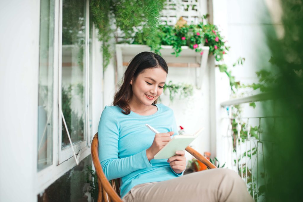 Woman journaling in a balcony