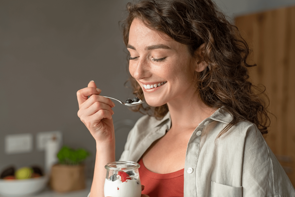 woman eating plain low glycemic yogurt with fruits