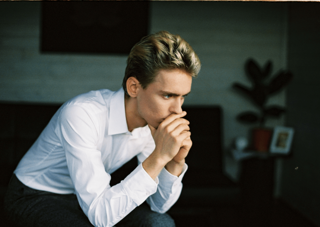 young man worried with his hands over his mouth