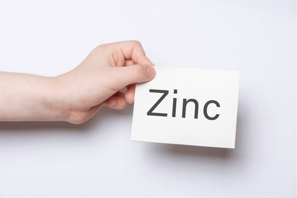 hand holding a sign zinc mineral