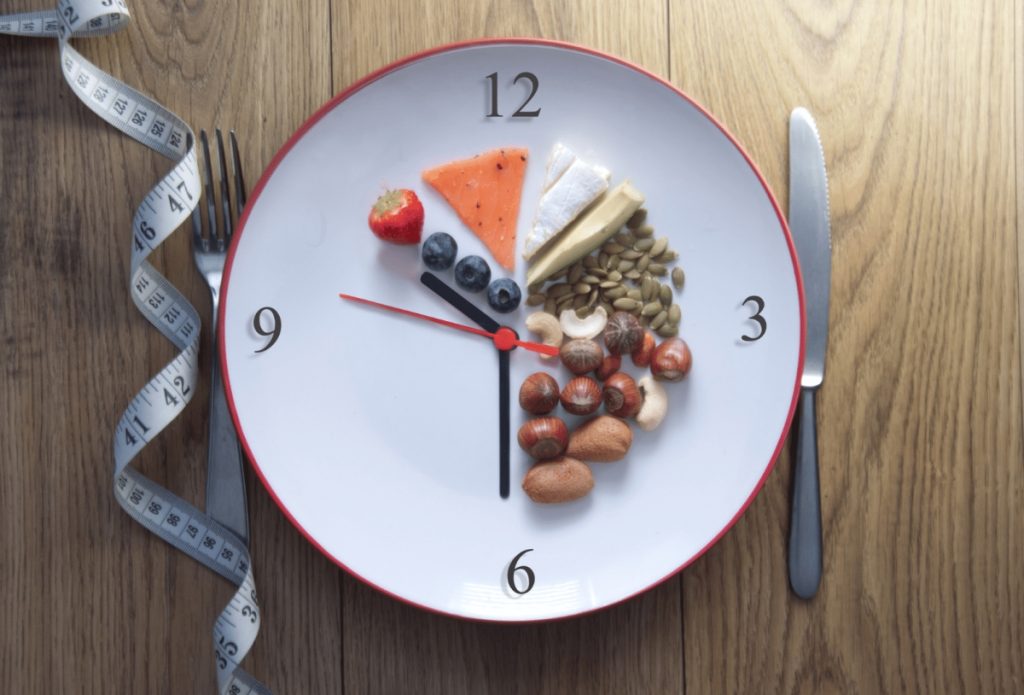 plate clock , silverware and measuring tape over the table 