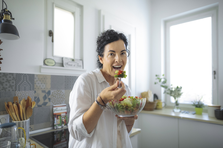 Woman At home eating salad