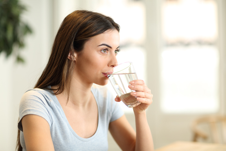 Woman drinking water at home