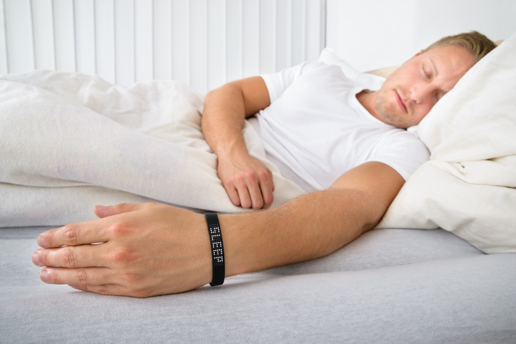 Portrait Of A Man Sleeping On Bed Wearing Smart Wristband