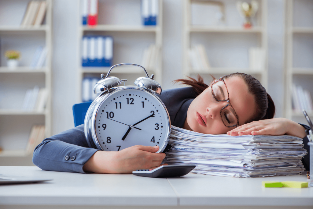 woman sleeping over paperwork hugging a clock