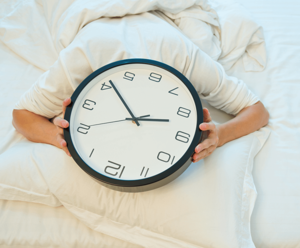 man in bed with a clock over is head