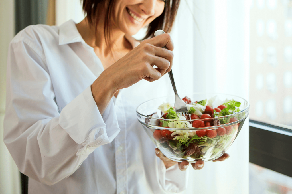 close up of a woman eating a greek salad