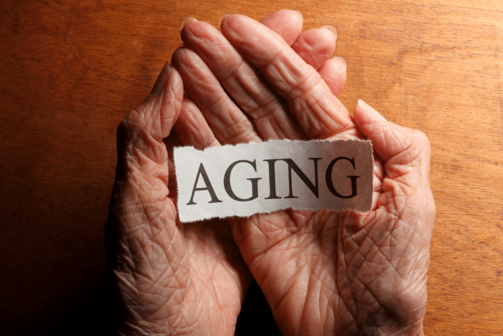 hands of an elderly with a paper that says aging