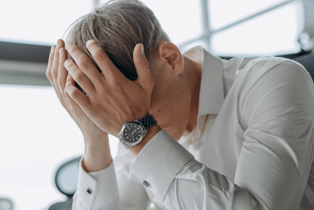 fatigue man with hands over his head