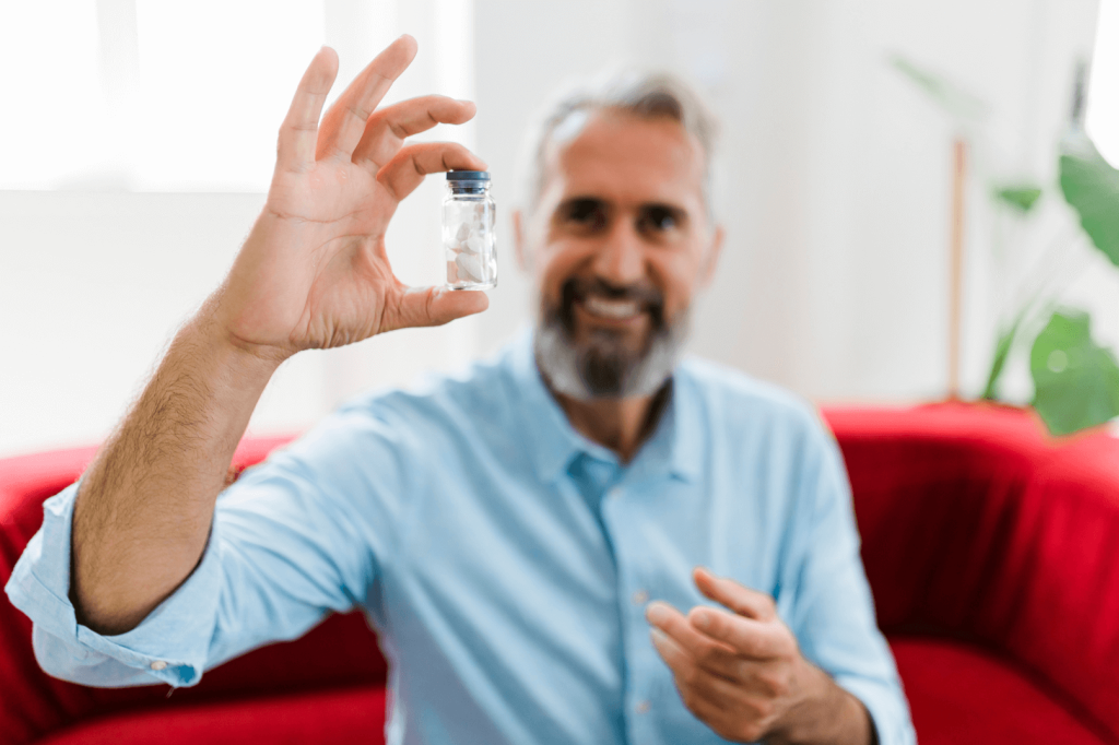 man holding a bottle of magnesium and smiling 