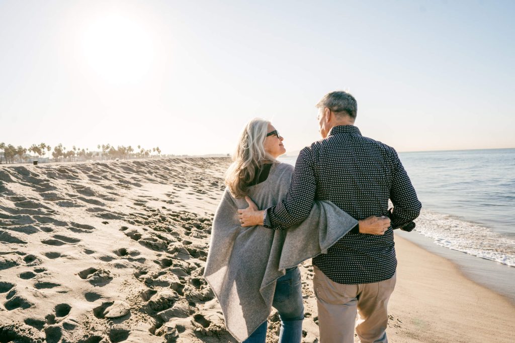 elder couple walking in the beach