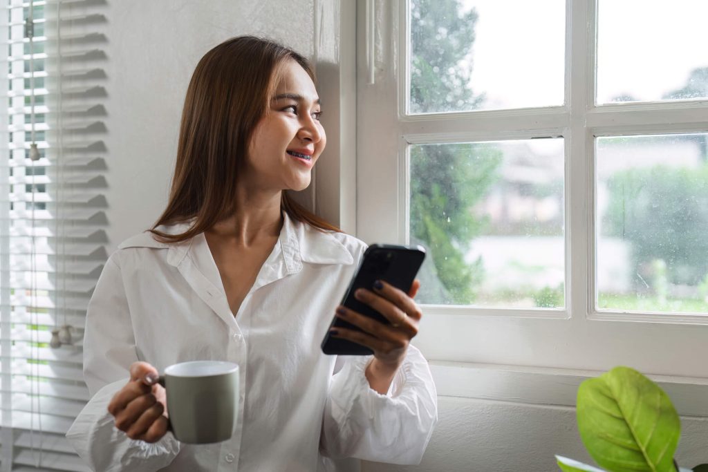 woman drinking coffee in the morning looking at the window