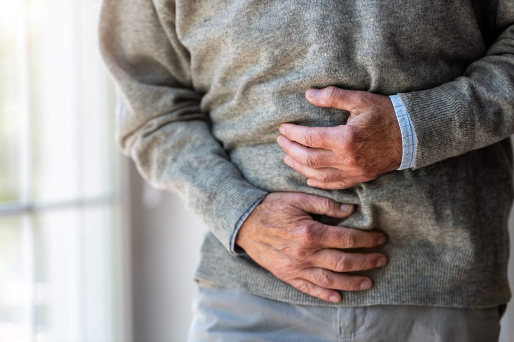 older man grabbing stomach