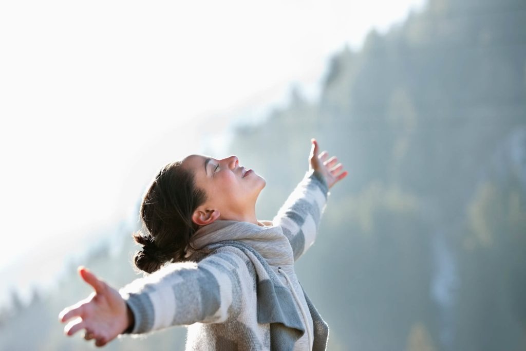 woman in nature open arms happy