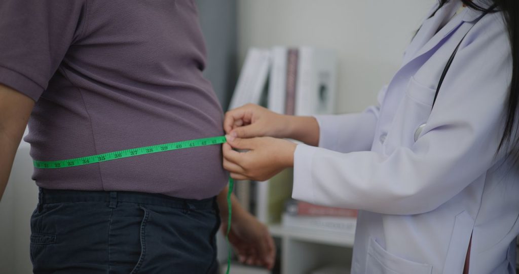 man measuring his waist