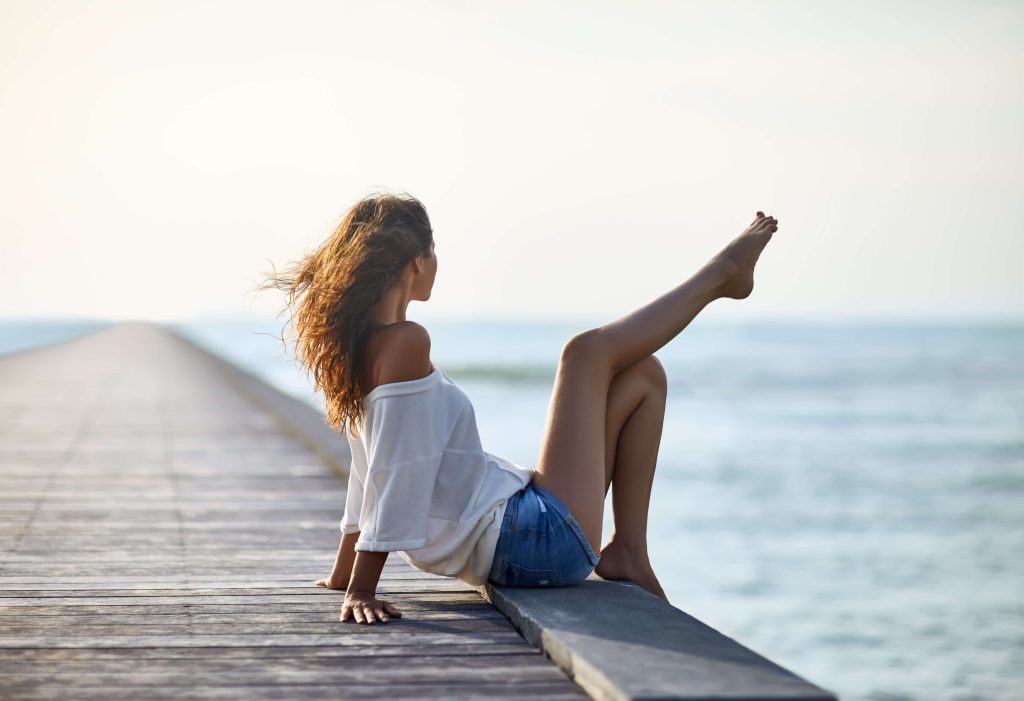 girl at a pierre looking at the ocean