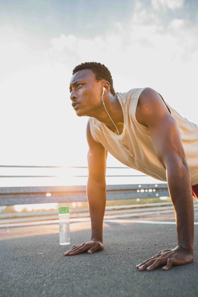 Young African-American male doing push-ups, outdoors