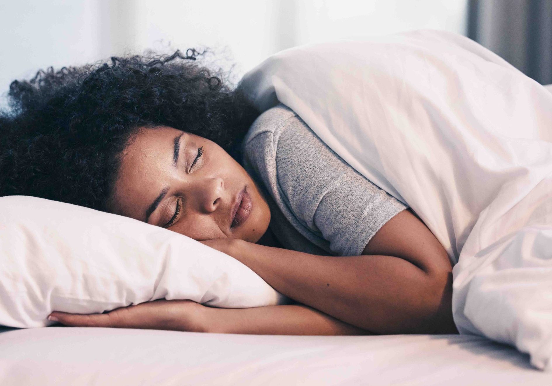 Sleeping, African woman and bed with morning nap in home with rest feeling calm with peace. House, bedroom and tired female person relax and comfortable on a pillow with blanket dreaming on weekend