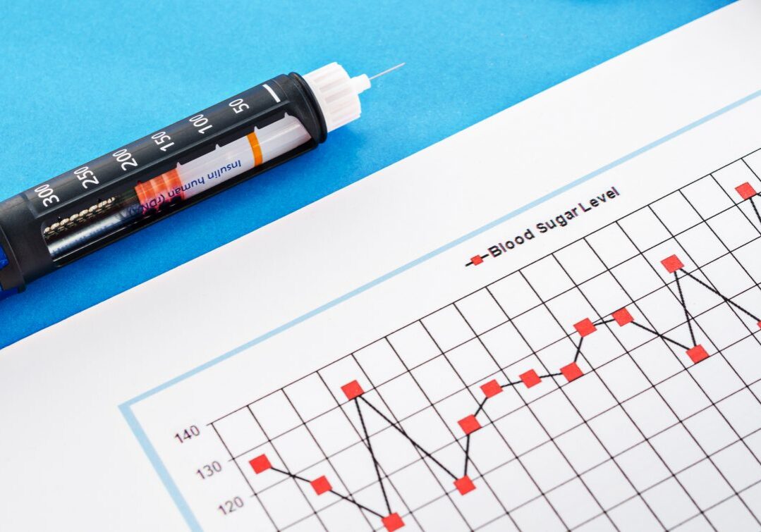 Insulin injection pen with blood sugar level monitoring chart on blue background.