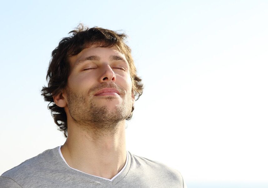 Attractive man breathing outdoor with the sky in the background