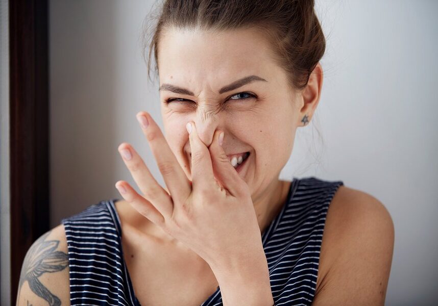 Female gesture smells bad. Headshot woman pinches nose with fingers hands looks with disgust something stinks bad smell situation. Human face expression body language reaction