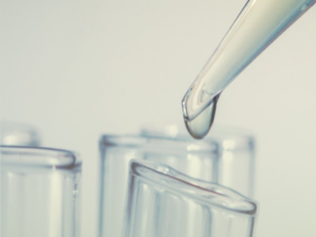 Lab pipette dropping liquid into test tubes