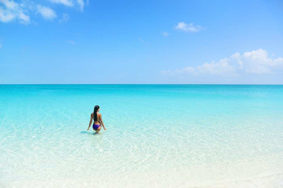 Beach holiday person swimming in blue ocean. Sexy bikini woman r ...